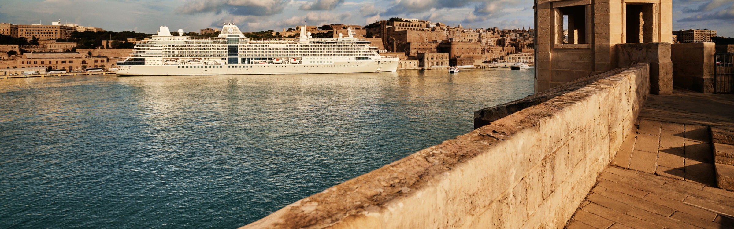 A luxury ship at anchor in Valletta's Grand Harbour, Malta, at golden hour